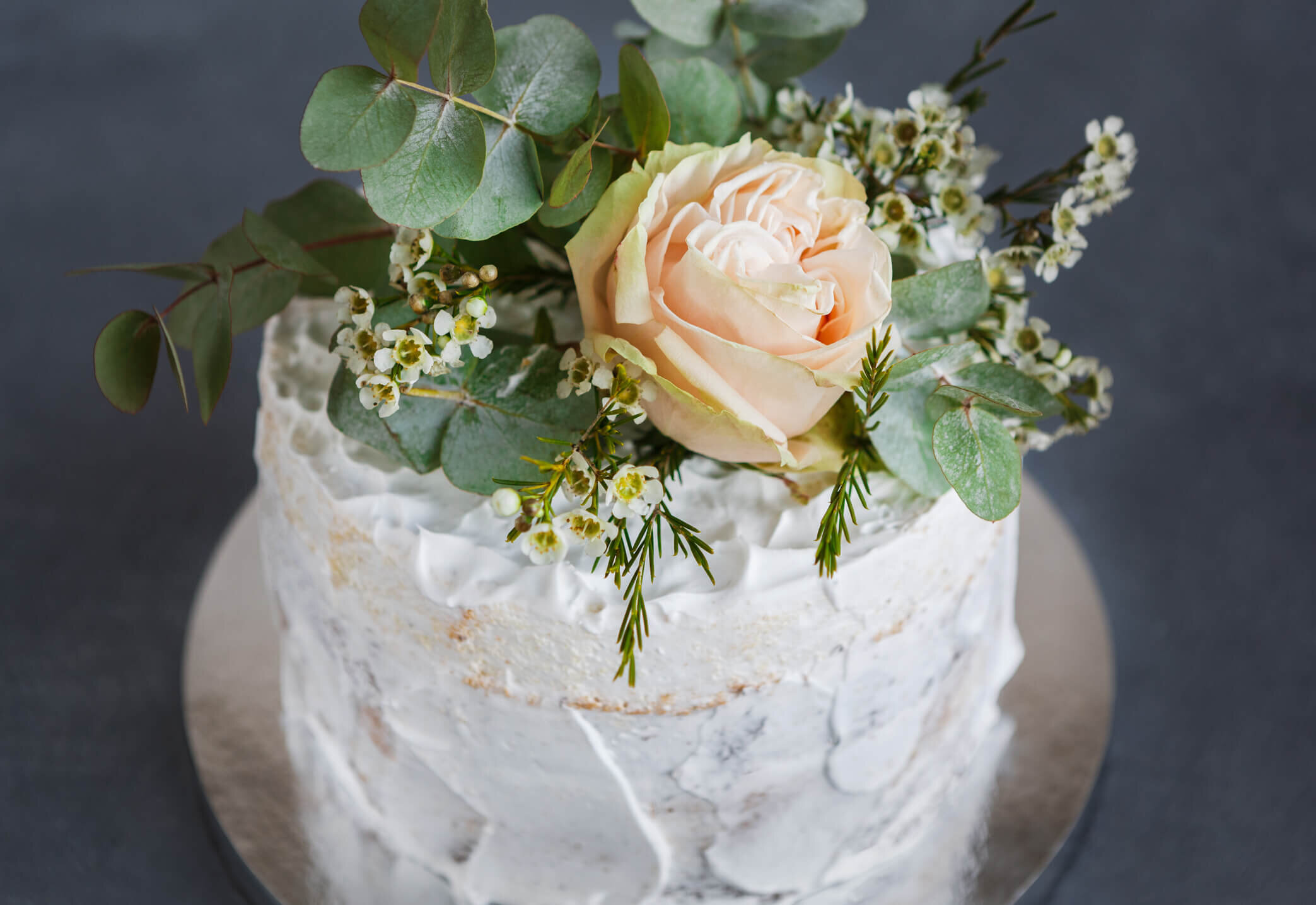 Wedding cake with white frosting and pink flower.jpg