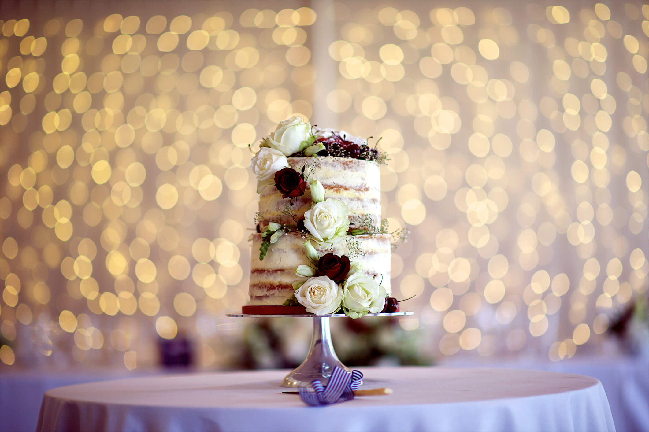 beautiful wedding cake with flowers sitting on table