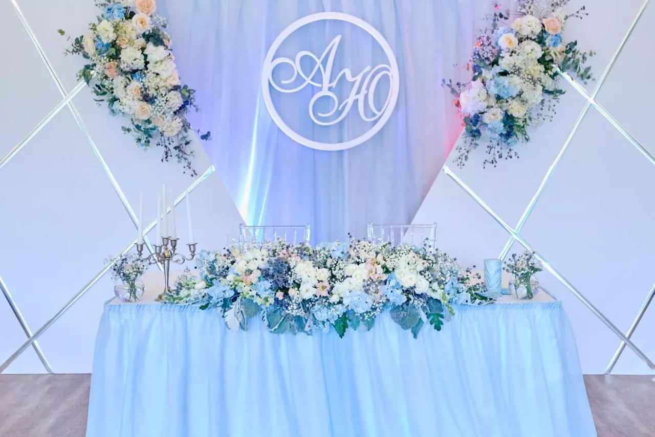 beautiful wedding head table with flowers and monogram sign