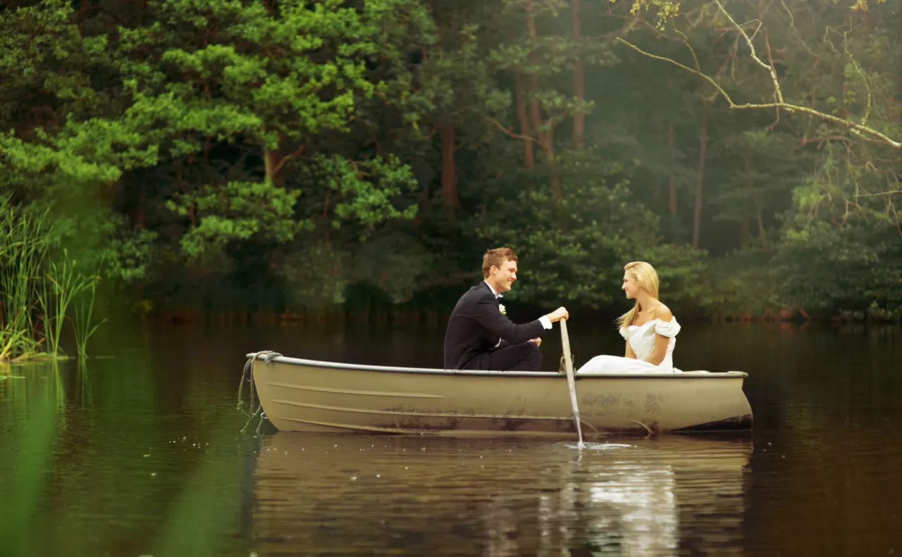 bride and groom in canoe at pond wedding