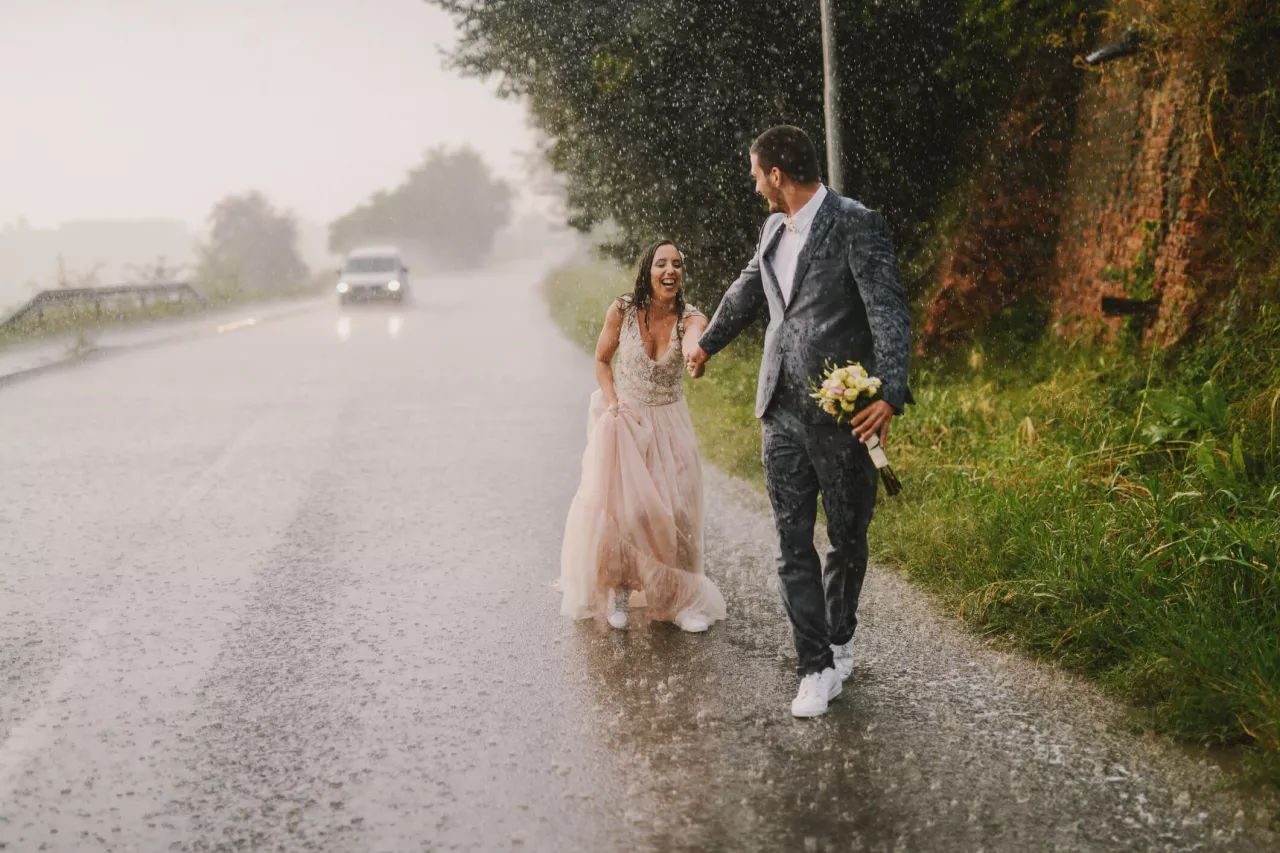 bride and groom walking in the rain