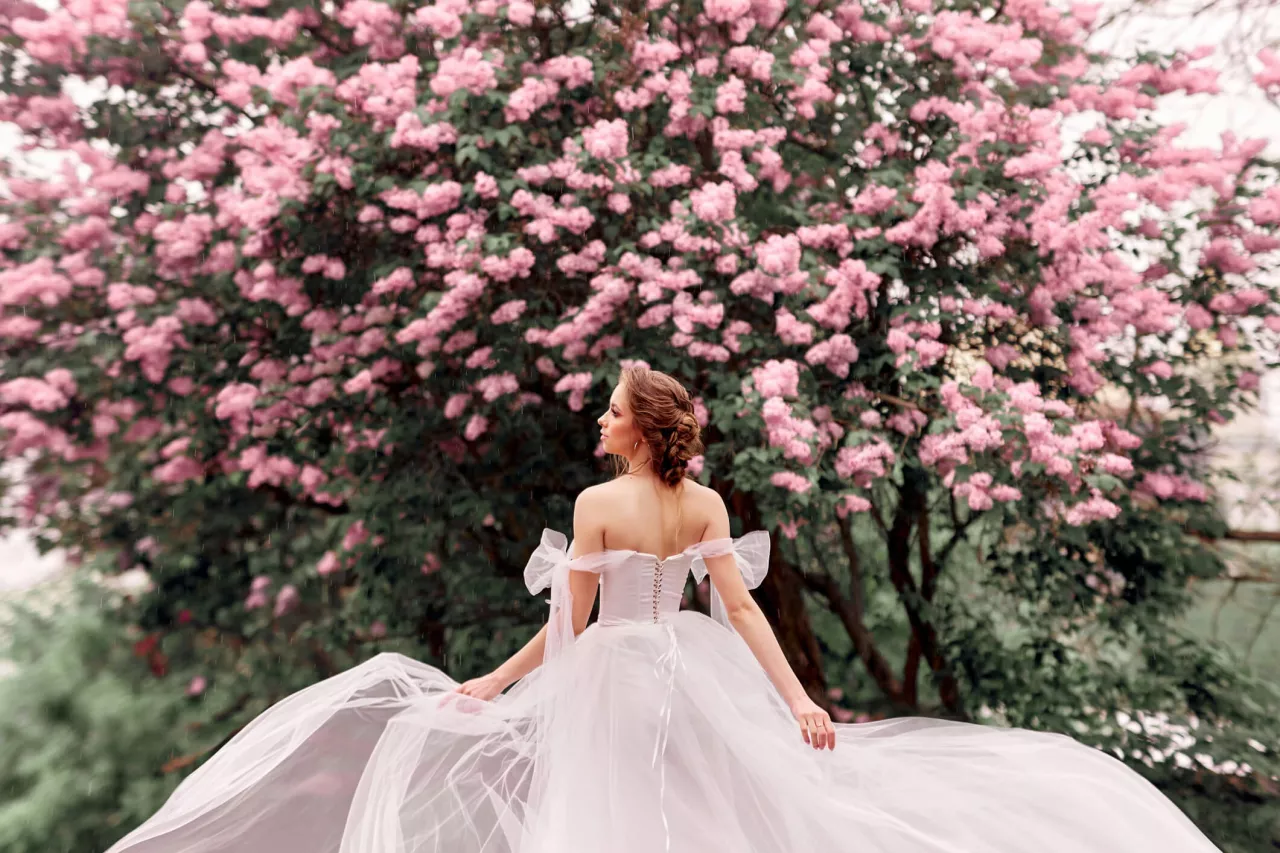 bride in a wedding dress in front of a cherry tree