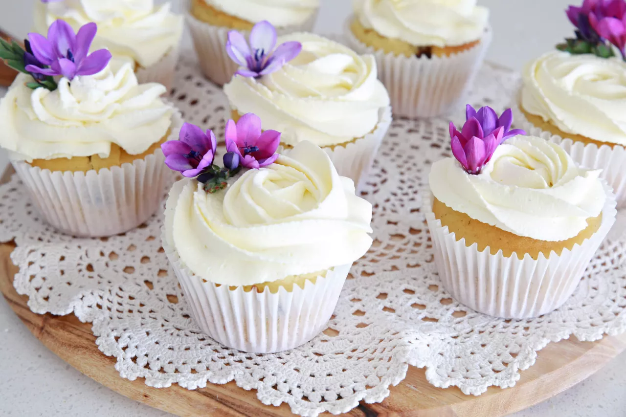 wedding cupcakes with white icing and purple flowers