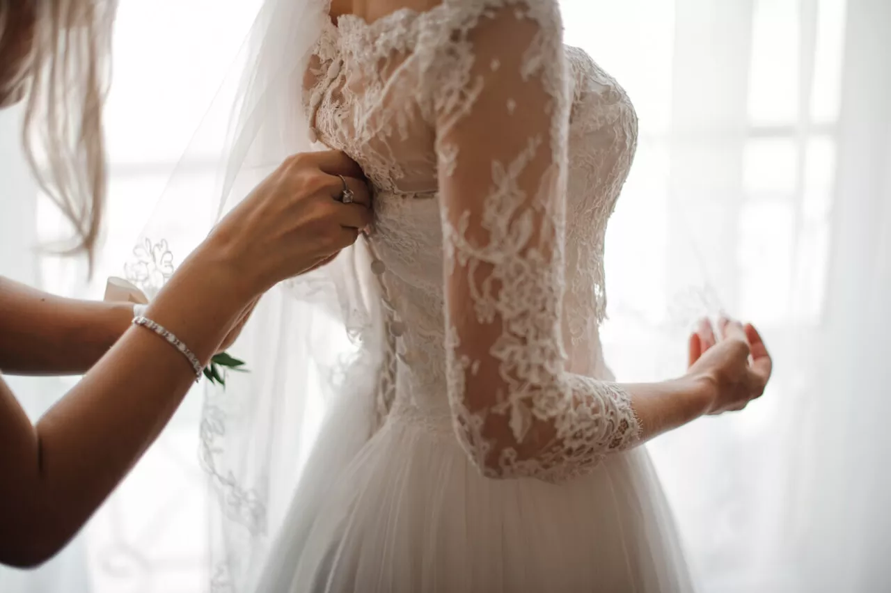 bride trying on wedding dress