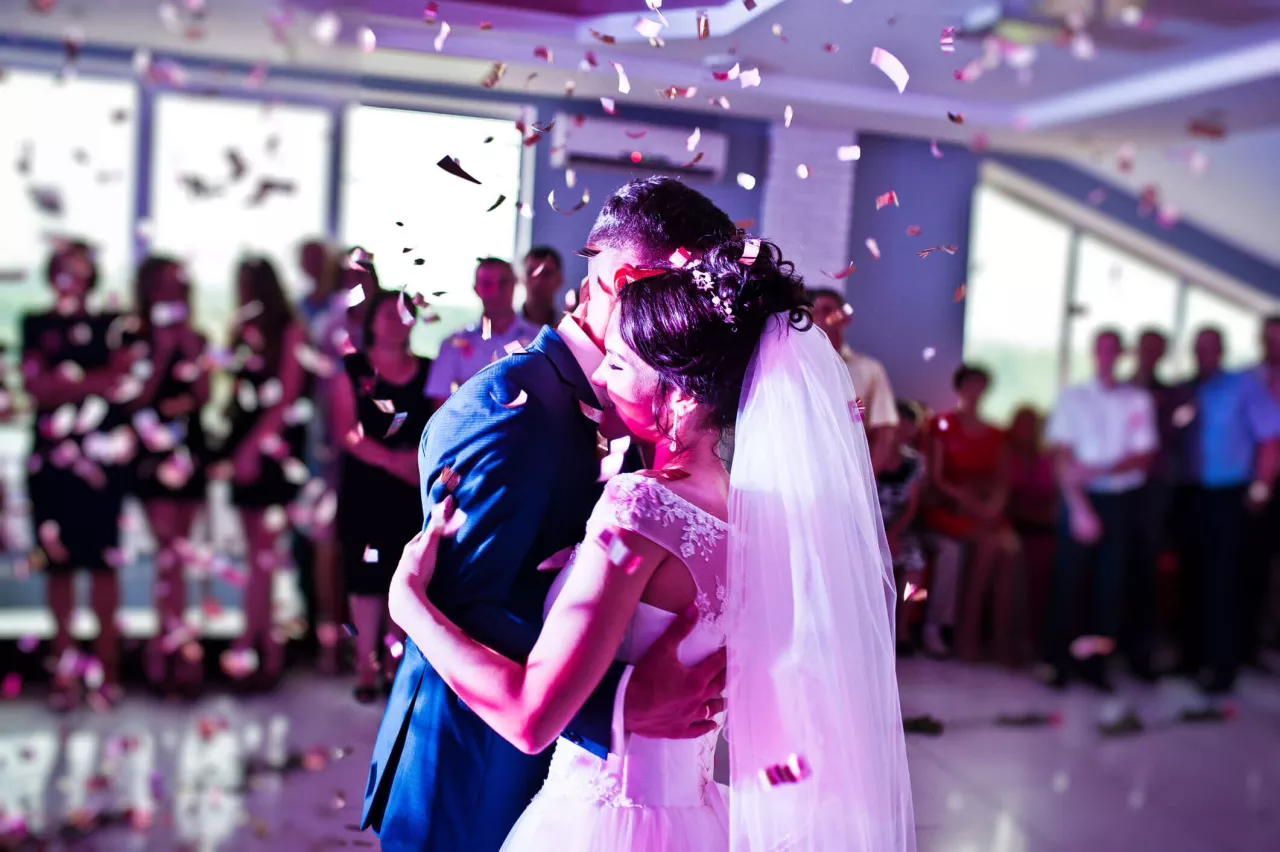 couple dancing at wedding with purple lights and confetti