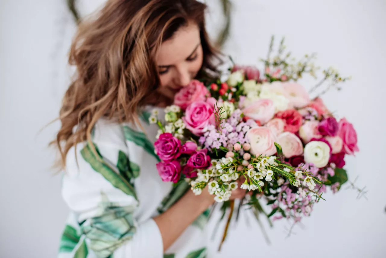 woman florist arranging wedding bouquet