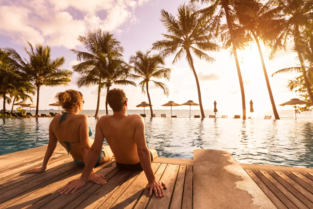 couple enjoying honeymoon at tropical pool overlooking ocean