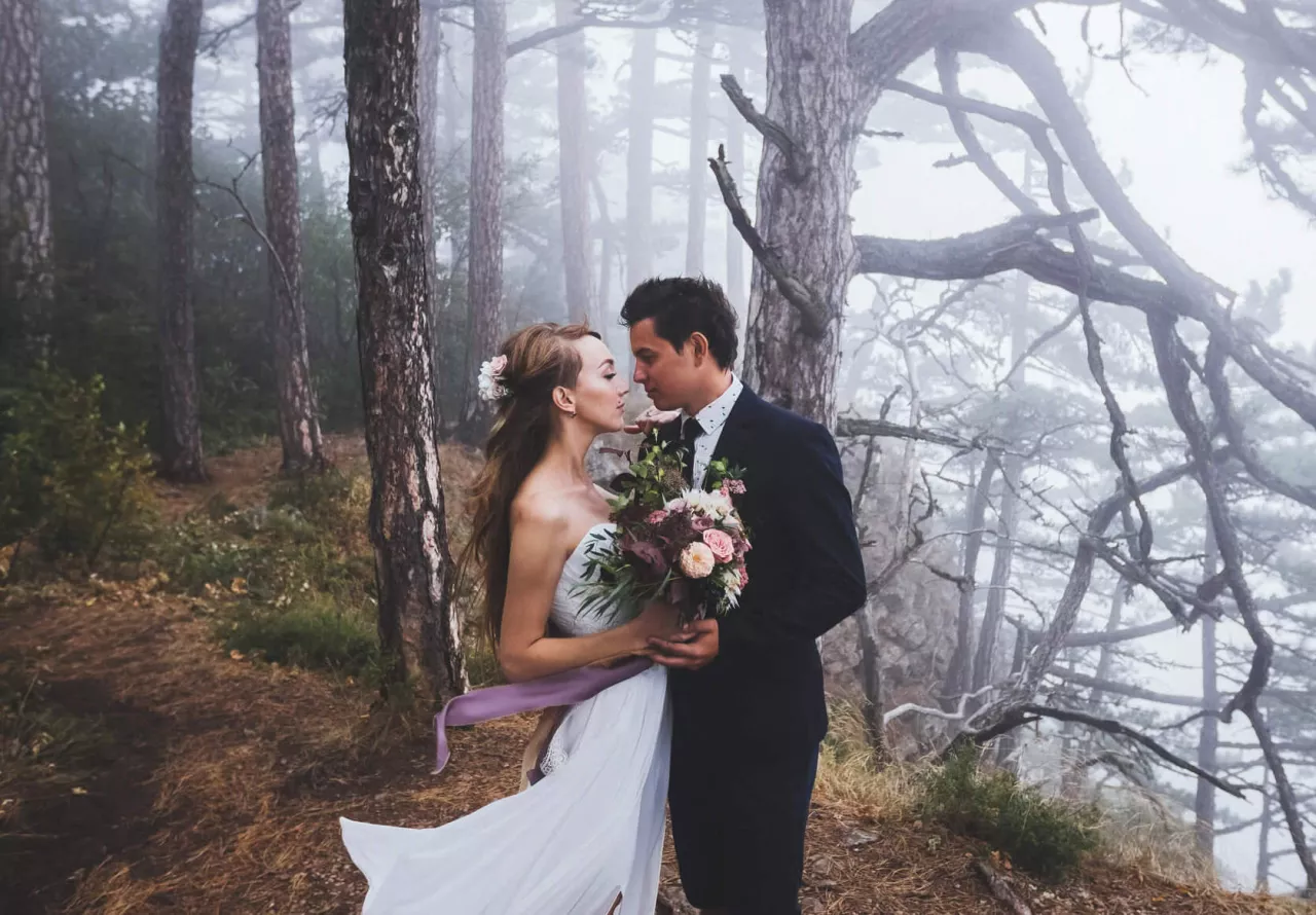 bride and groom embracing in mystical forest