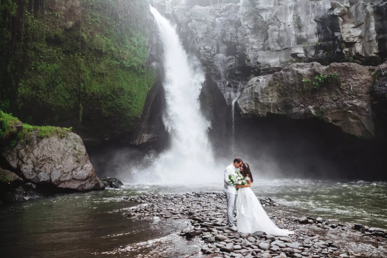 bride and groom embracing at waterfall wedding venue