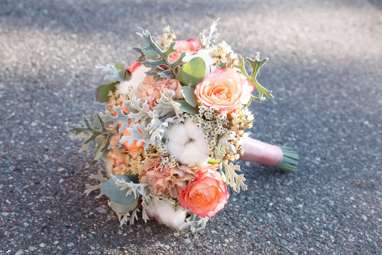 Orange white and green wedding bouquet placed on ground