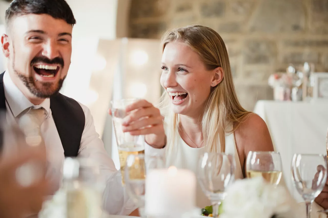 wedding guests laughing and smiling at table