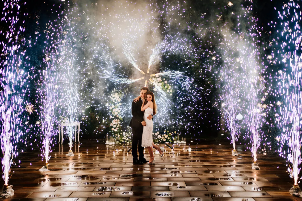 bride and groom posing with fireworks during 4th of july wedding