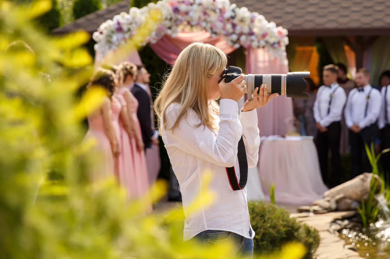 Wedding photographer with a professional camera working at a wedding ceremony