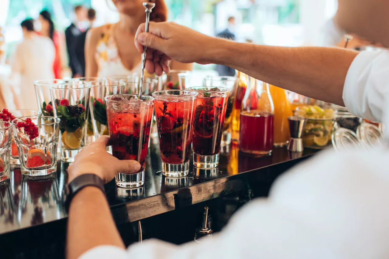 bartender making cocktails at open bar wedding