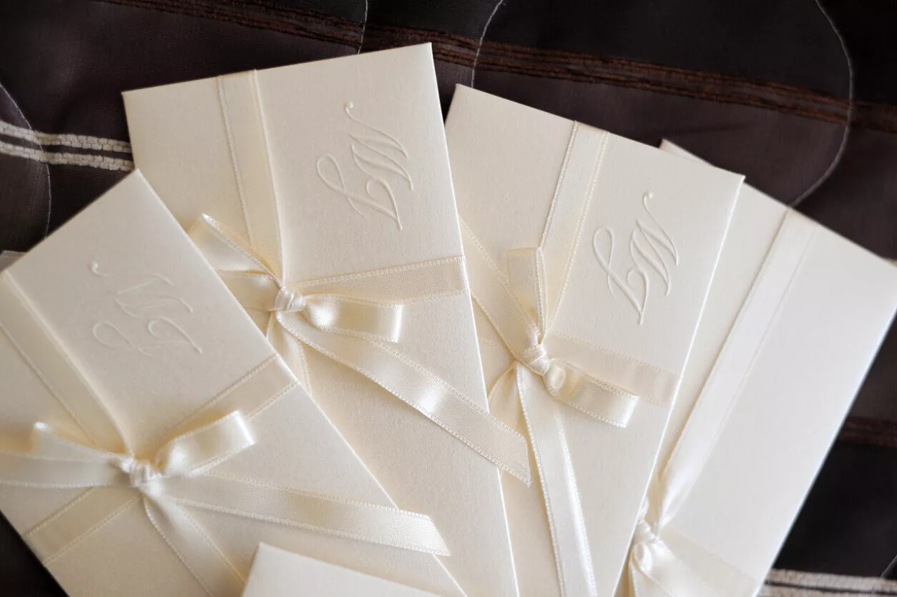 close up of all-white wedding invitations
