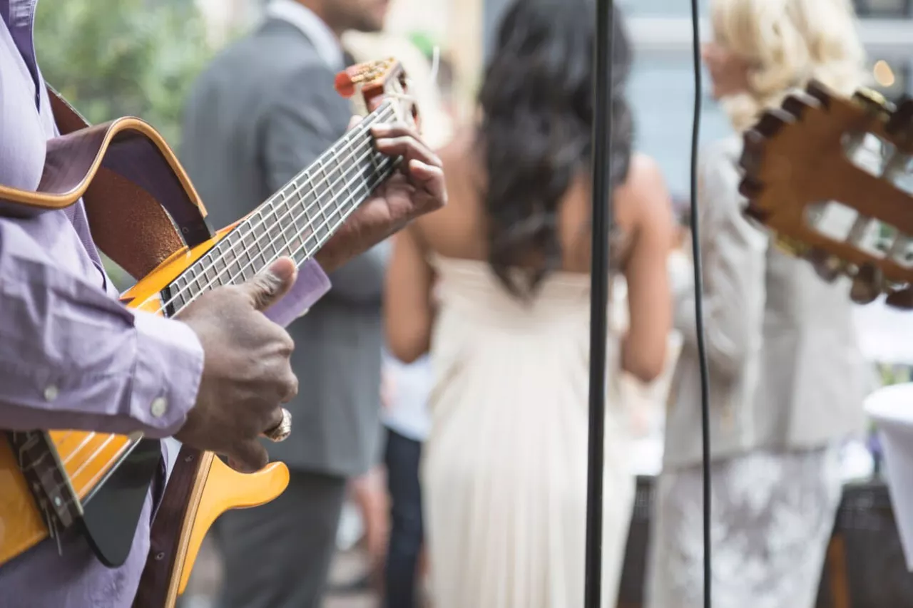 man playing guitar music during wedding cocktail hour