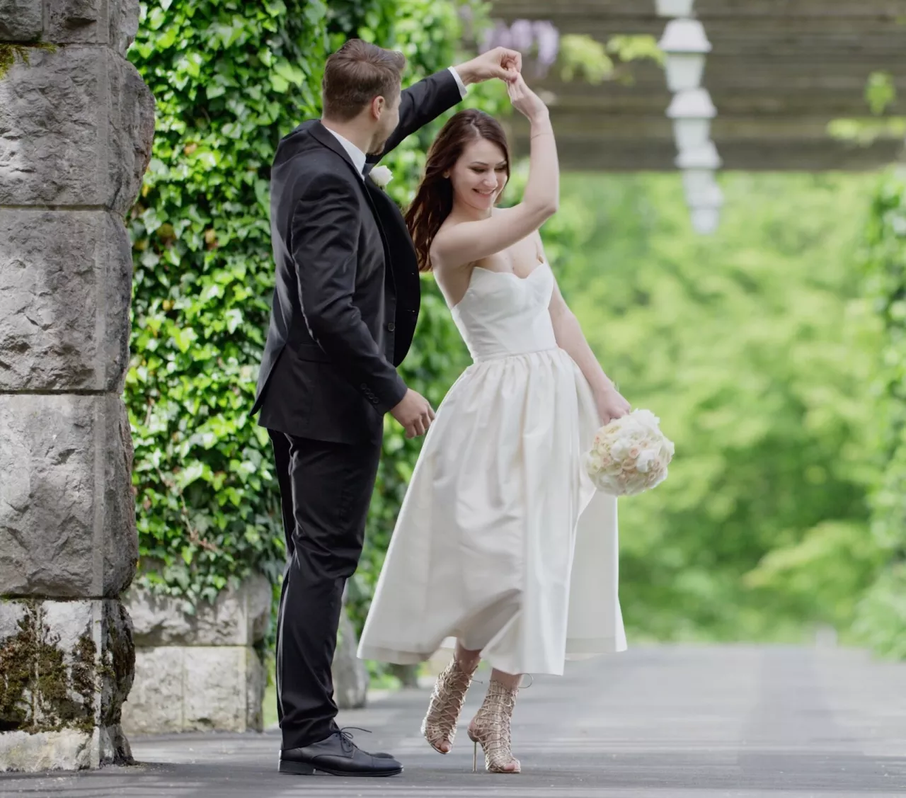 bride and groom dancing with greenery