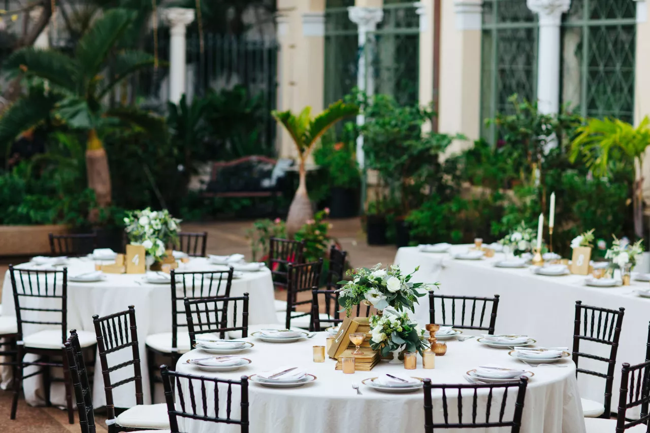 Wedding venue with greenery and white tablecloths