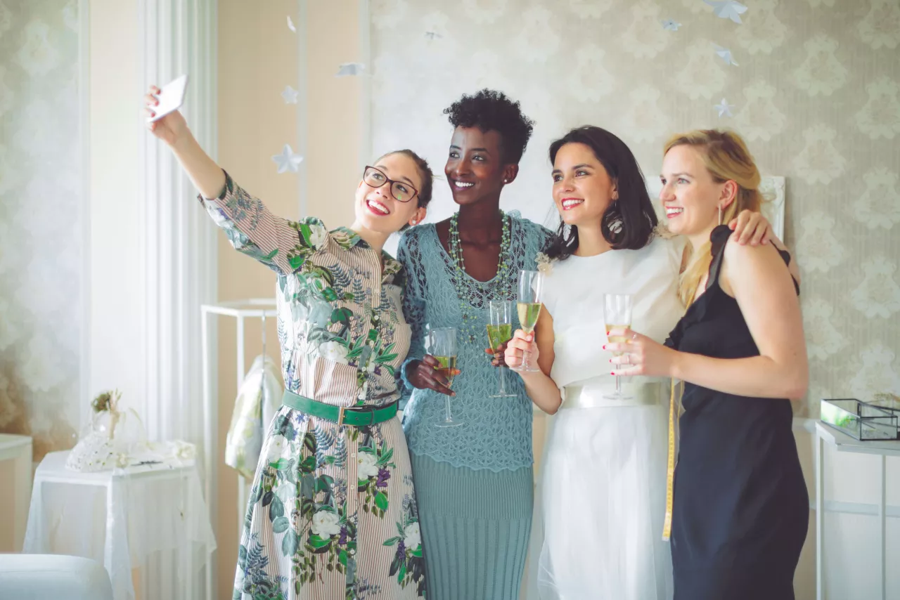 Women taking selfie holding champagne