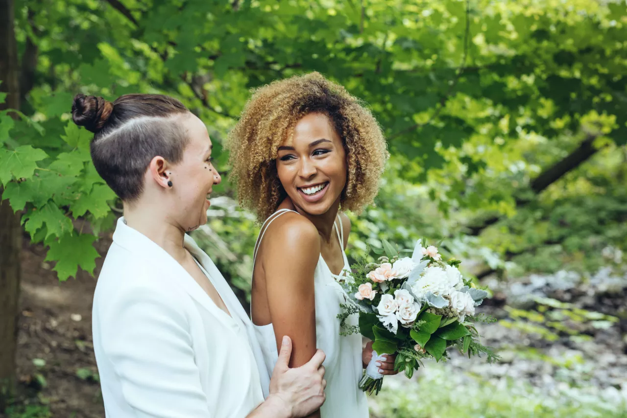 Two women smiling at each other in woods
